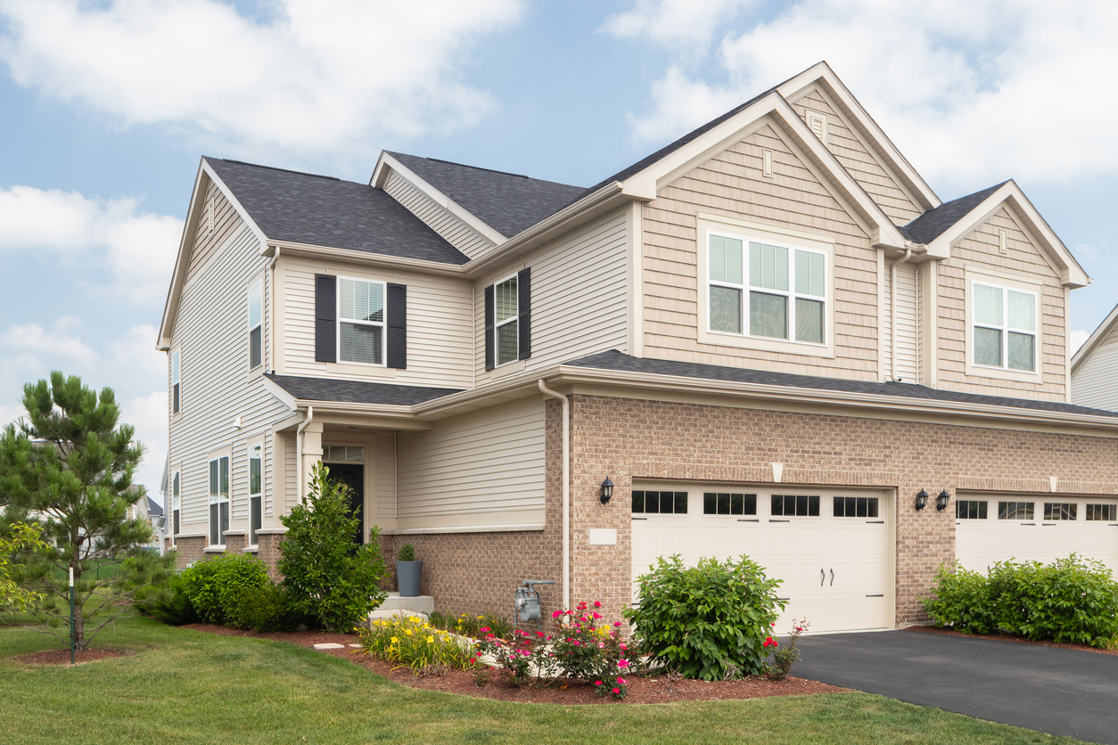 a large brick building with grass in front of a house